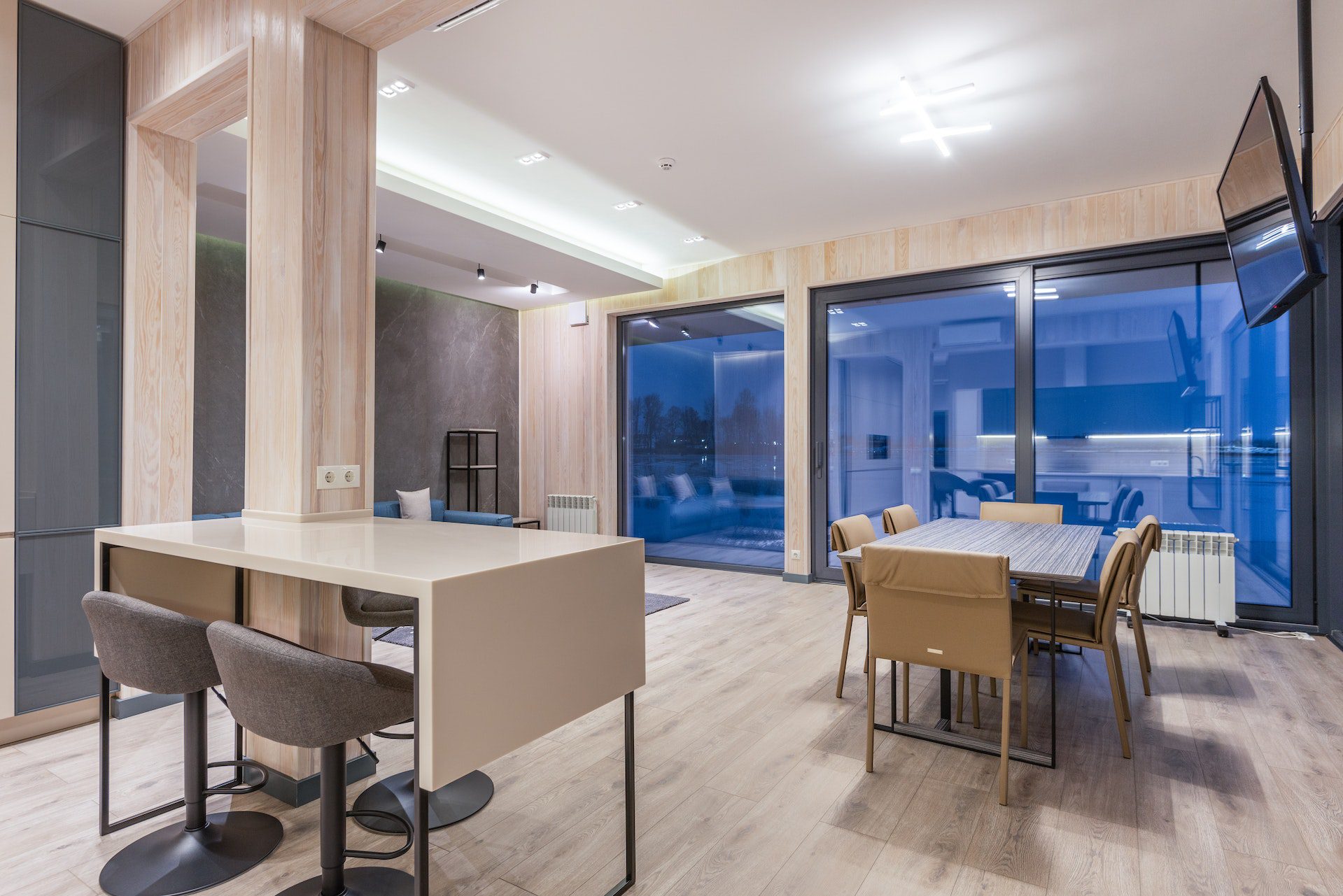 Interior of contemporary house with wooden furniture and glass panoramic windows Interior of contemporary house with wooden furniture and glass panoramic windows<br />